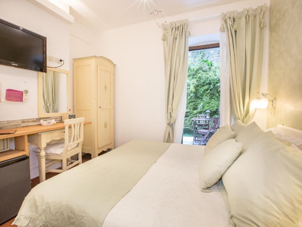 a bedroom with a bed with a desk and a window at Hotel Marina in Monterosso al Mare
