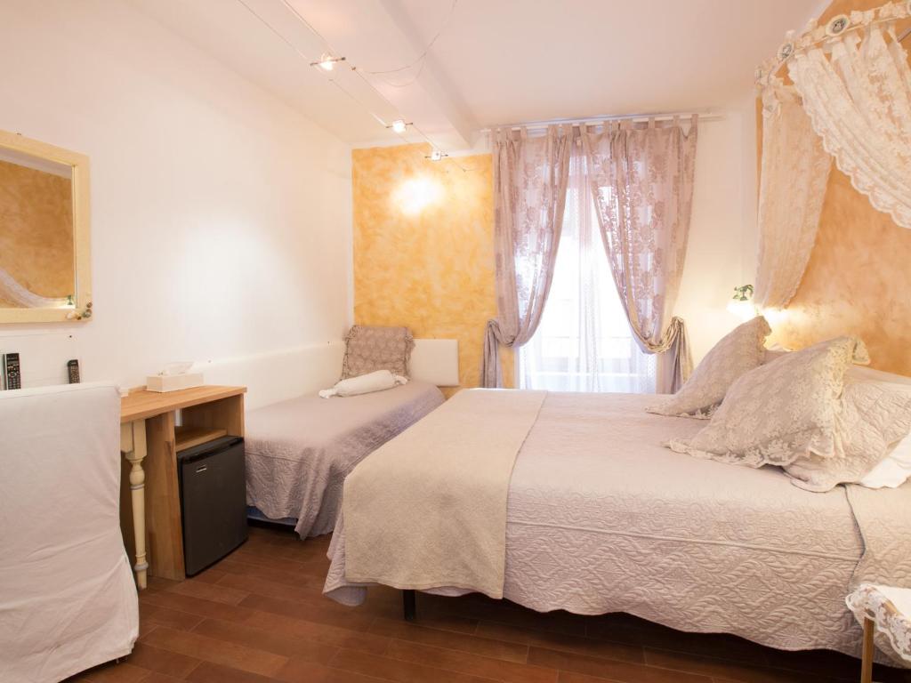 a bedroom with two beds and a desk and a window at Hotel Marina in Monterosso al Mare