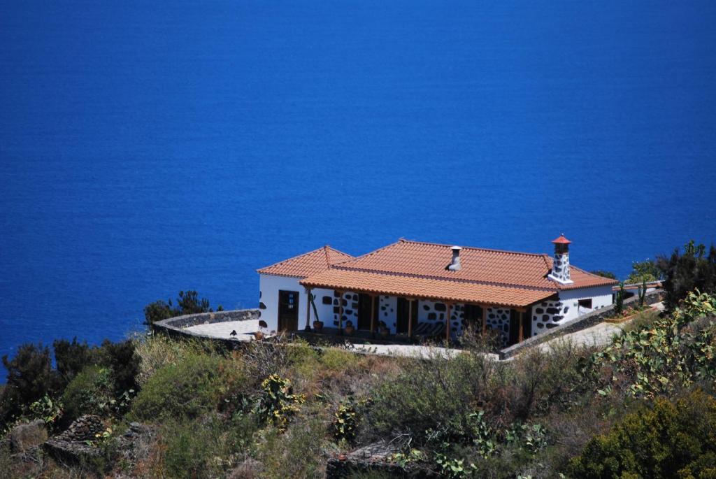 Casa Rural Los Barranquitos في Garafía: منزل على قمة تل بجوار المحيط