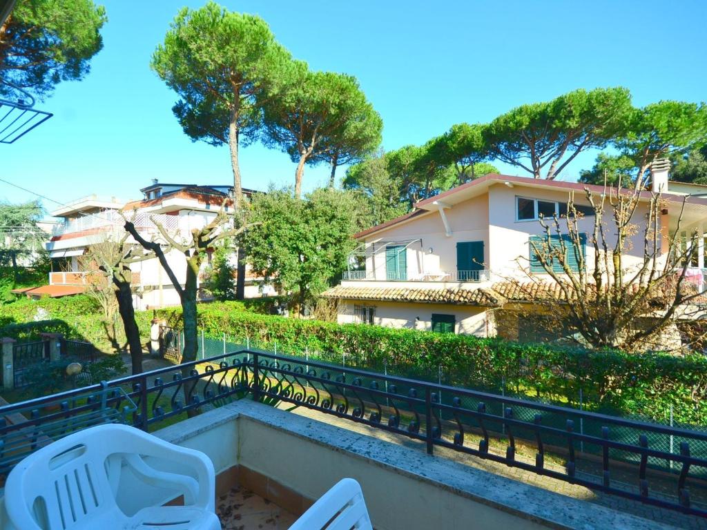 a balcony with white chairs and a building at Modern Holiday Home in Massa with Garden in Marina di Massa