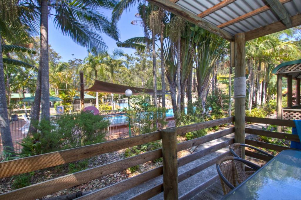 a wooden fence with a table and chairs and a playground at BIG4 Twin Dolphins Holiday Park in Tuncurry