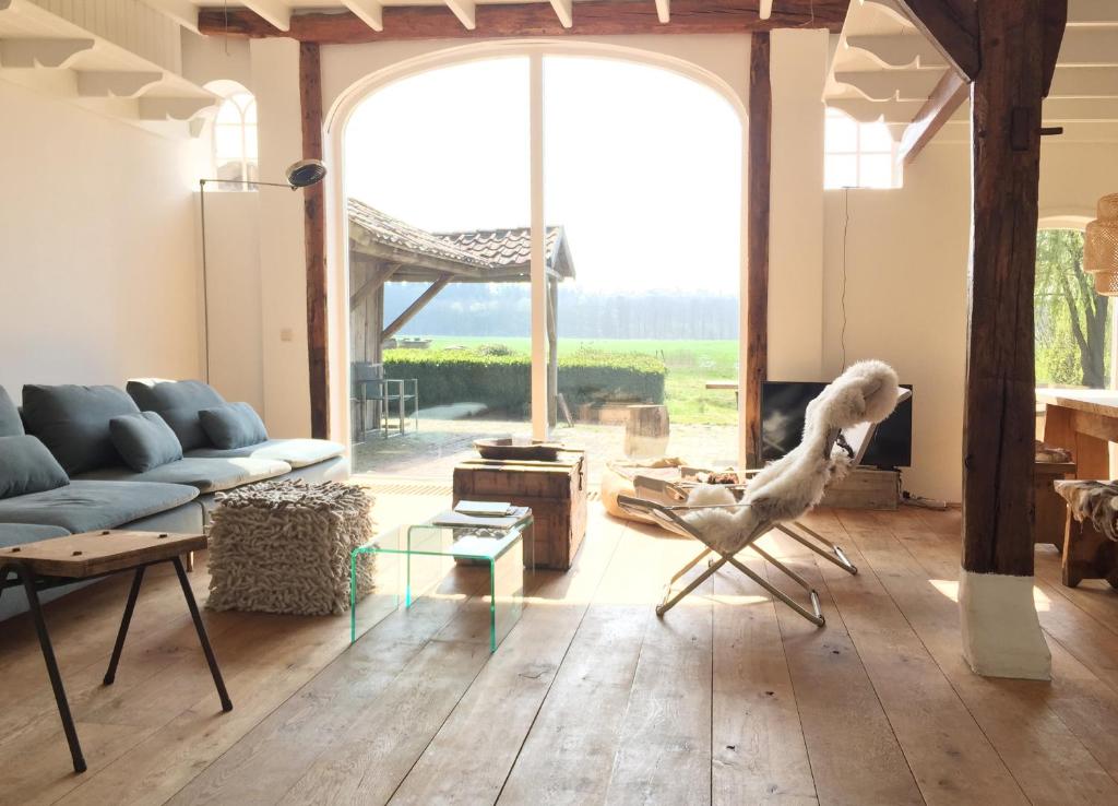 - un salon avec un canapé et une grande fenêtre dans l'établissement Fietsboerderij, à Sinderen