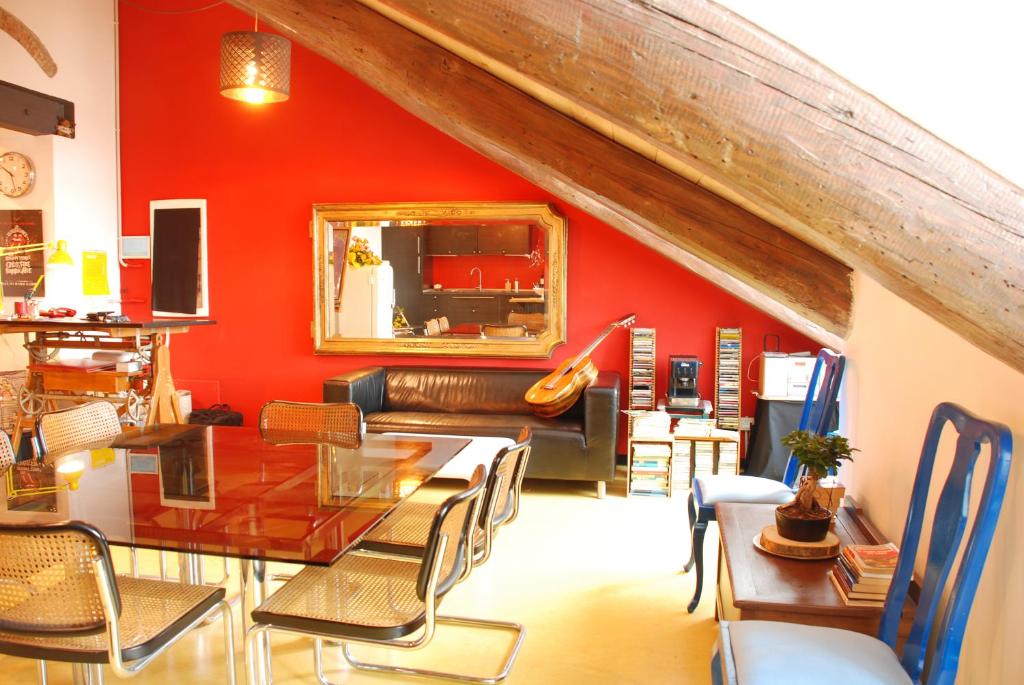 sala de estar con paredes rojas, mesa y sillas en Attic Hostel Torino, en Turín