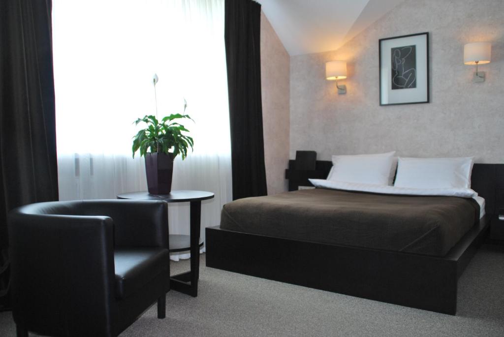 トゥーラにあるGrand Hotel Clubのベッドルーム1室(ベッド1台、椅子、窓付)