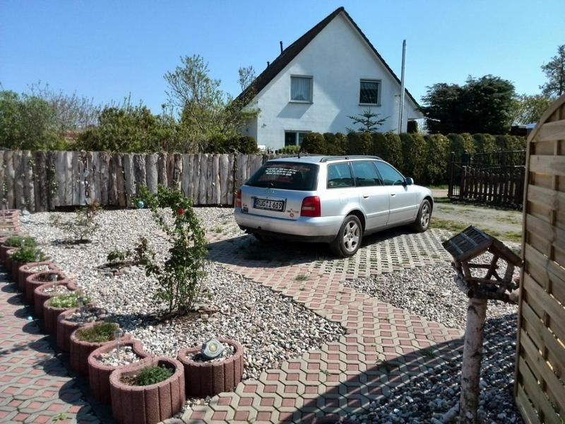 une voiture garée dans une allée devant une maison dans l'établissement FERIENBUNGALOW Schwanck in Sagard, à Sagard