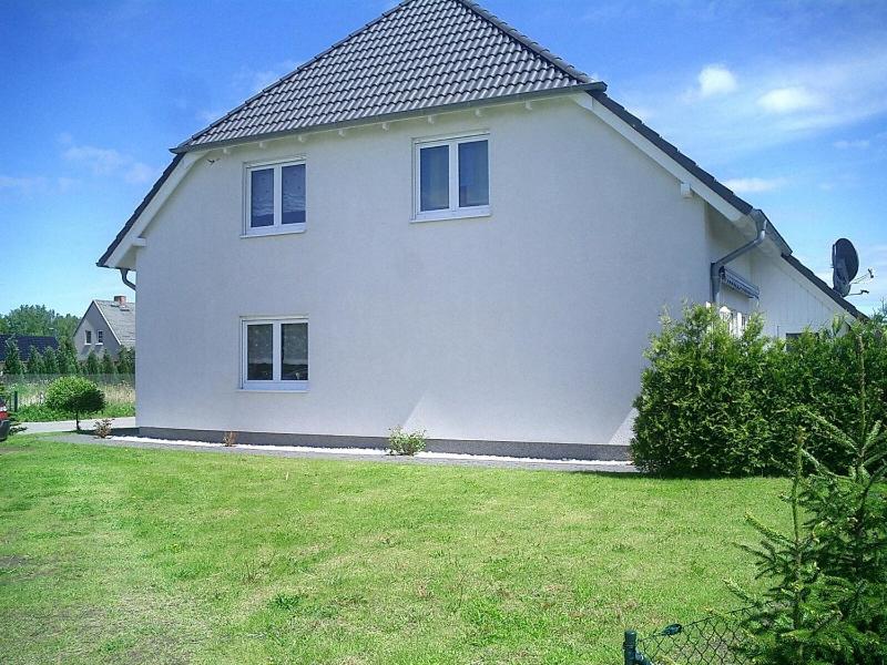 ツィノヴィッツにあるFerienhaus Zinnowitzの芝生の庭のある大きな白い家