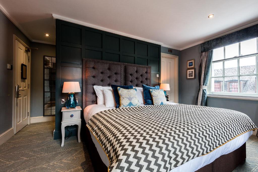 a bedroom with a large bed with a black wall at City Gate in Exeter