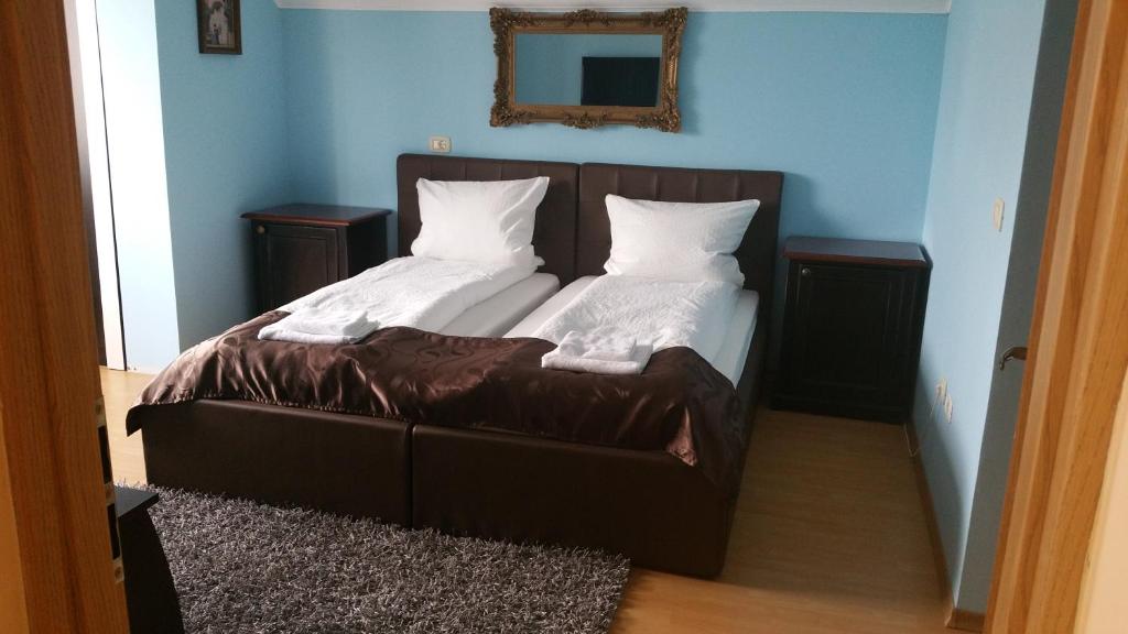 a bed with two pillows on it in a room at Family Pension in Arad