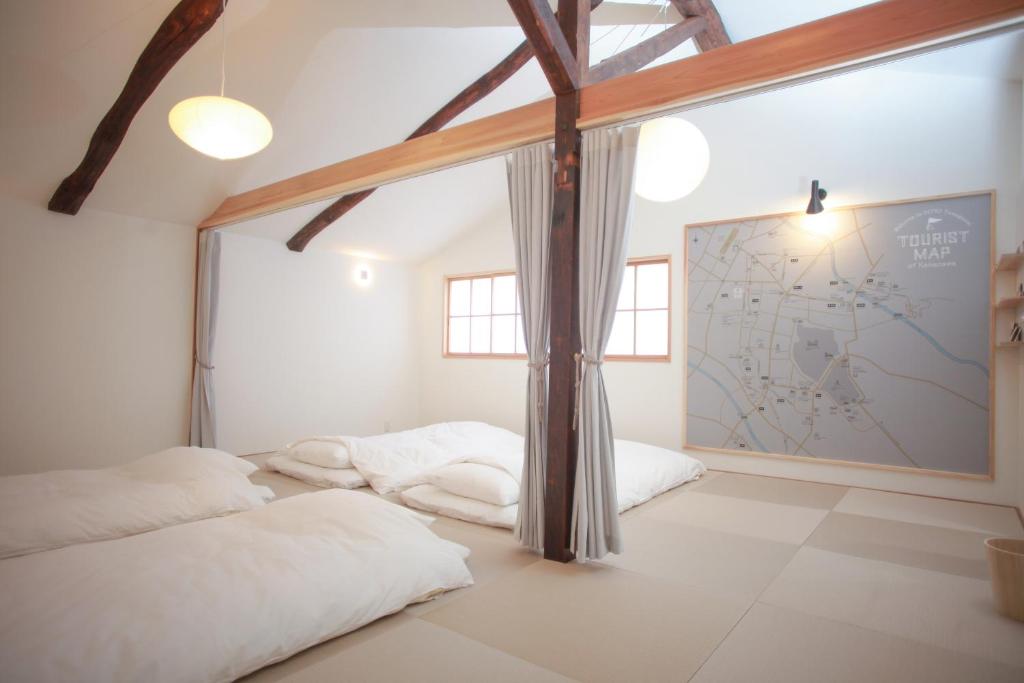 1 Schlafzimmer mit 3 Betten und einer Karte an der Wand in der Unterkunft INTRO Tamagawa in Kanazawa