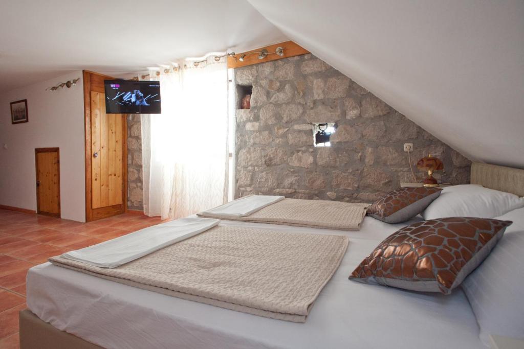 two beds in a room with a stone wall at Apartments Antica in Split