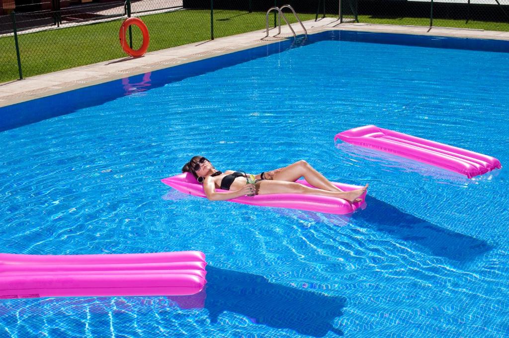 a woman laying on a raft in a swimming pool at Hotel Mirador de Chamartín in Madrid