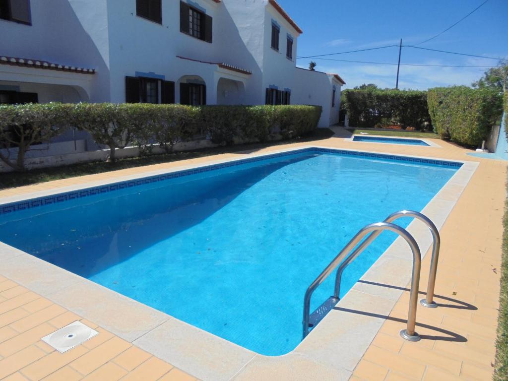 a swimming pool in front of a house at Apartamento Neptuno in Benagil