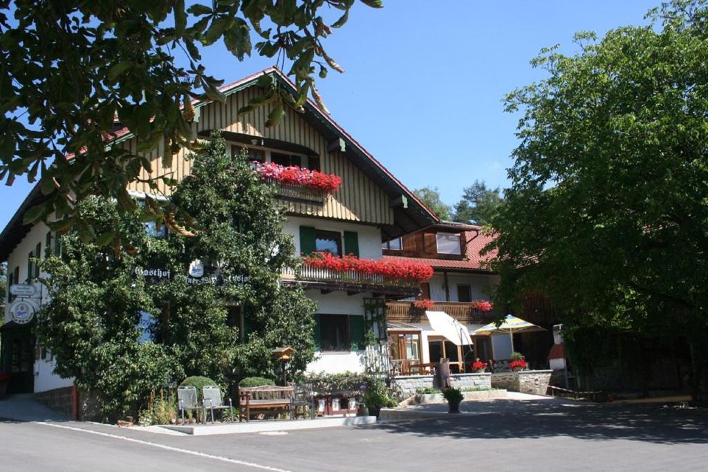 een gebouw met rode bloemen aan de zijkant bij Steiner Wirt in Tiefenbach