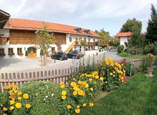 einen Zaun mit Blumen vor einem Gebäude in der Unterkunft Gasthof & Hotel Jägerwirt in Aufhofen