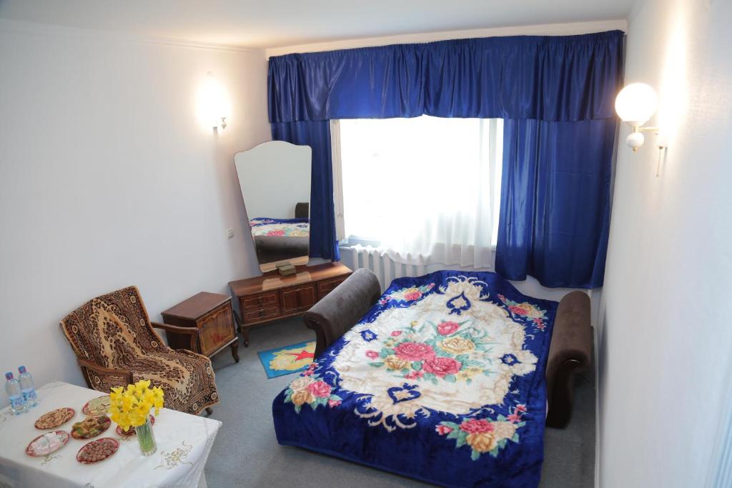 uma sala de estar com um sofá com um cobertor floral em Apartment on Samarqand Kochasi em Tashkent