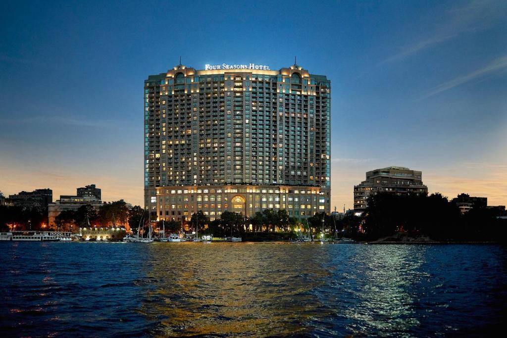 duży budynek przed dużym zbiornikiem wody w obiekcie Four Seasons Hotel Cairo at Nile Plaza w Kairze