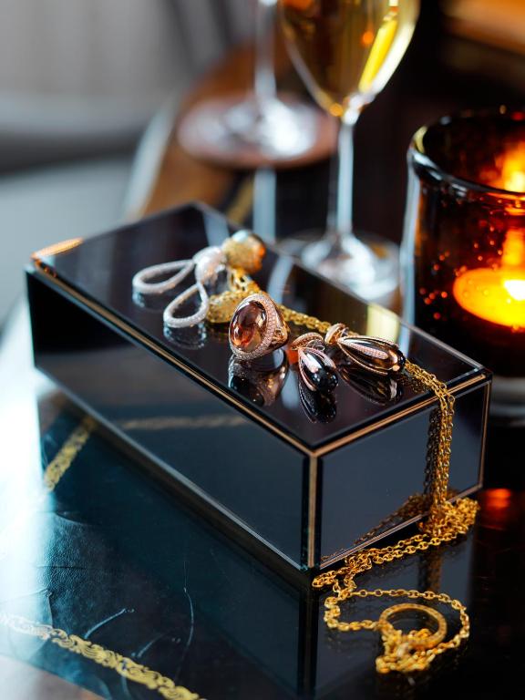 a black plate with a necklace and glasses on a table at Hotel Continental in Oslo