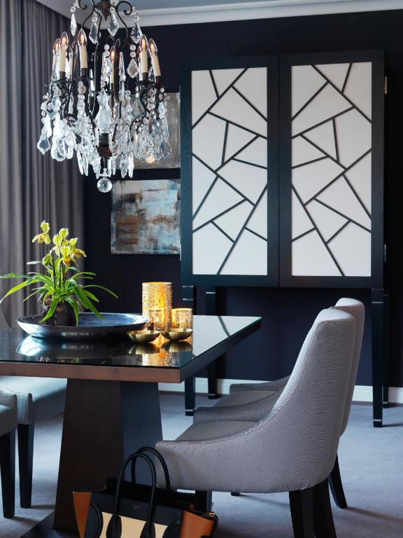 a dining room with a table and a chandelier at Hotel Continental in Oslo