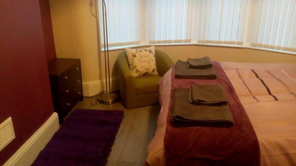 a bedroom with a bed with a chair and a couch at Liverpool At Gloucester Road - Infinity Apartments in Liverpool