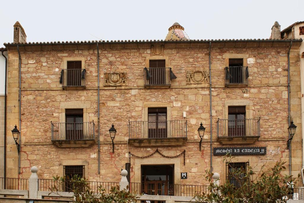 a large brick building with windows and balconies at Hostal Meson la Cadena in Trujillo