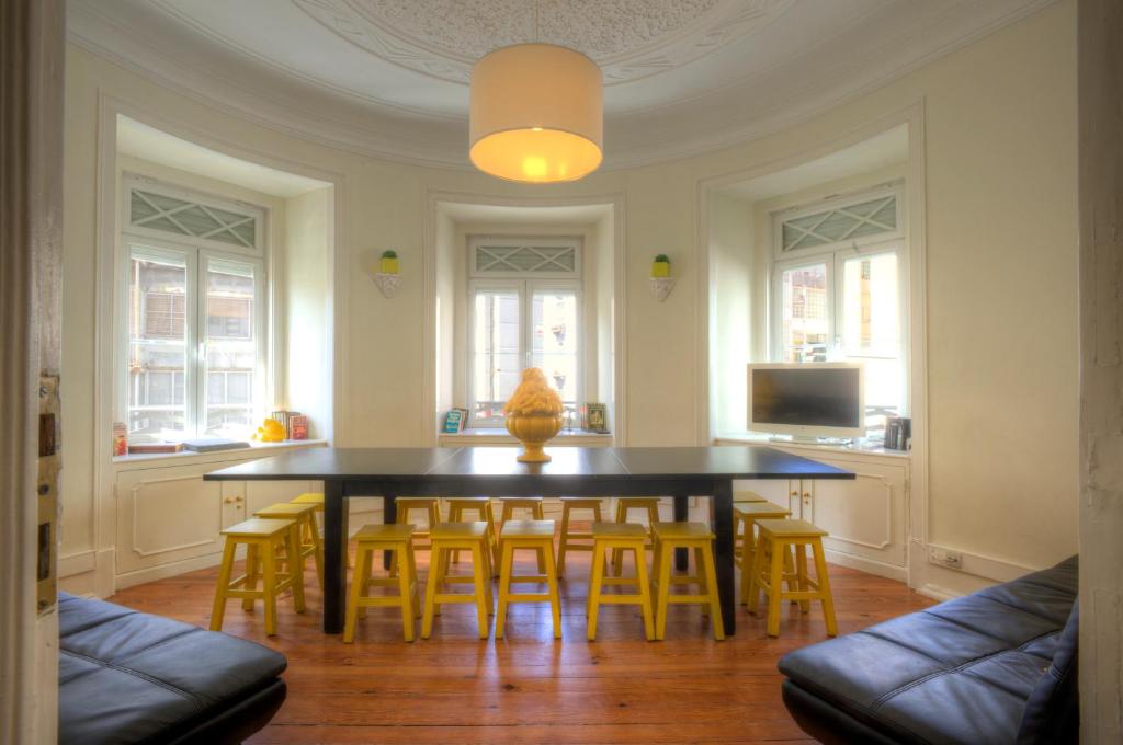 リスボンにあるAngola Apartment - 8Bedroomsのダイニングルーム(黒いテーブル、黄色い椅子付)