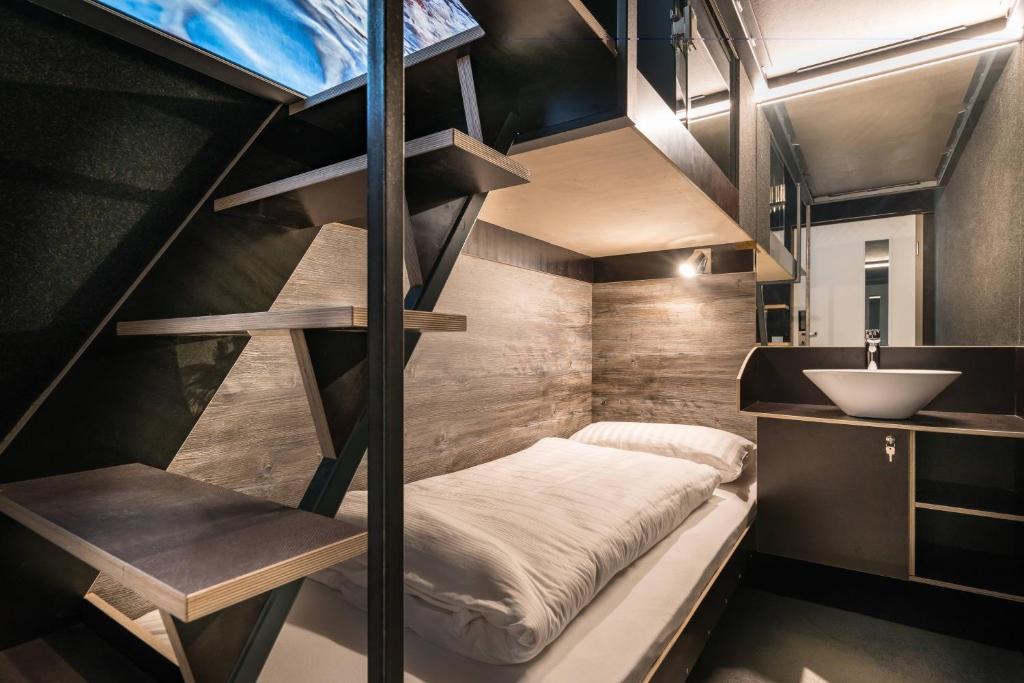 miniaturowy domek z łóżkiem piętrowym i umywalką w obiekcie BoxHotel Göttingen (App Based Hotel) w Getyndze