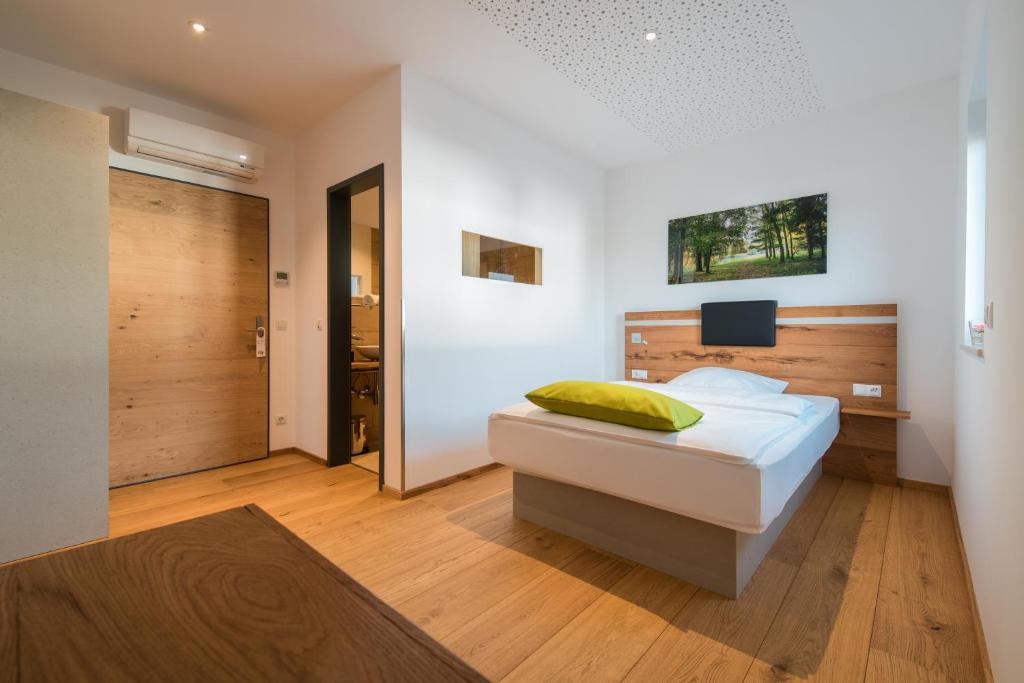 a bedroom with a bed and a door to a hallway at Aparthotel nah dran in Dingolfing