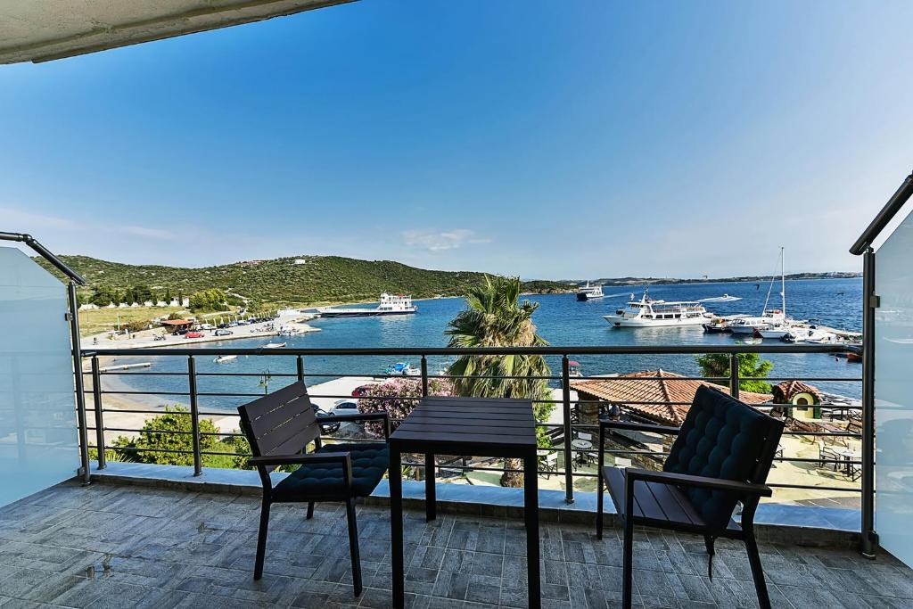 a balcony with a table and chairs and a view of a harbor at Pension Limani in Ammouliani