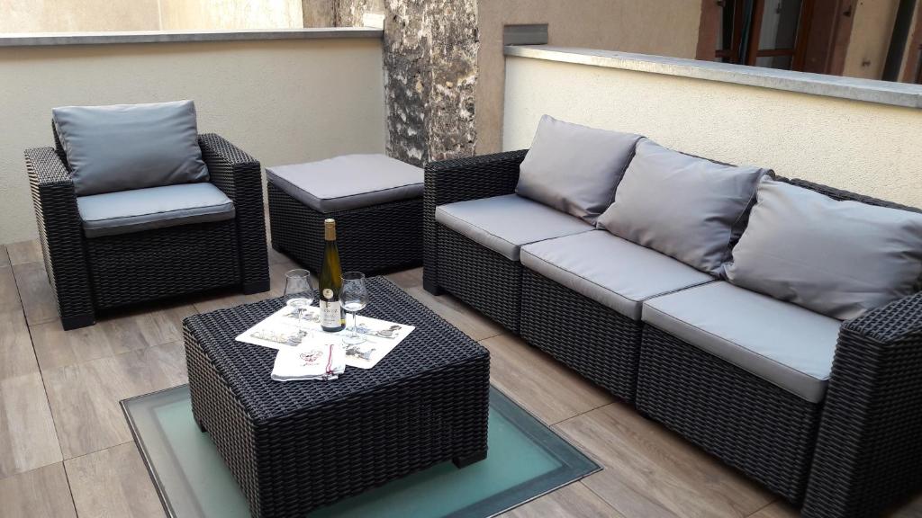 eine Terrasse mit einem Sofa, 2 Stühlen und einem Tisch in der Unterkunft Appartement avec terrasse "BARTHOLDI" in Colmar