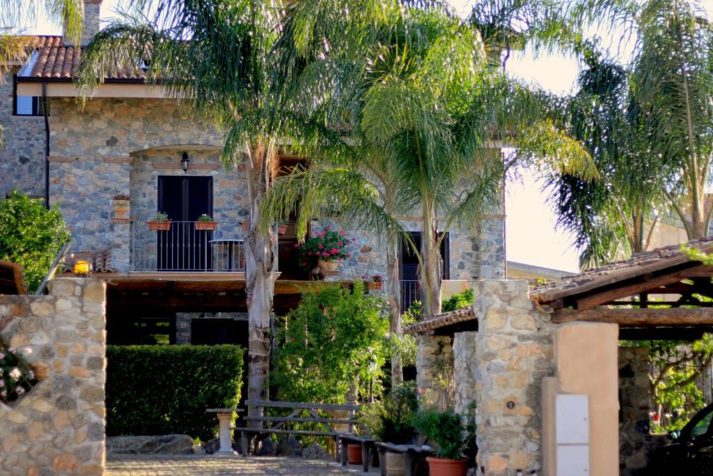 a house with palm trees in front of it at Villa Basilio Accommodation in Capo Vaticano