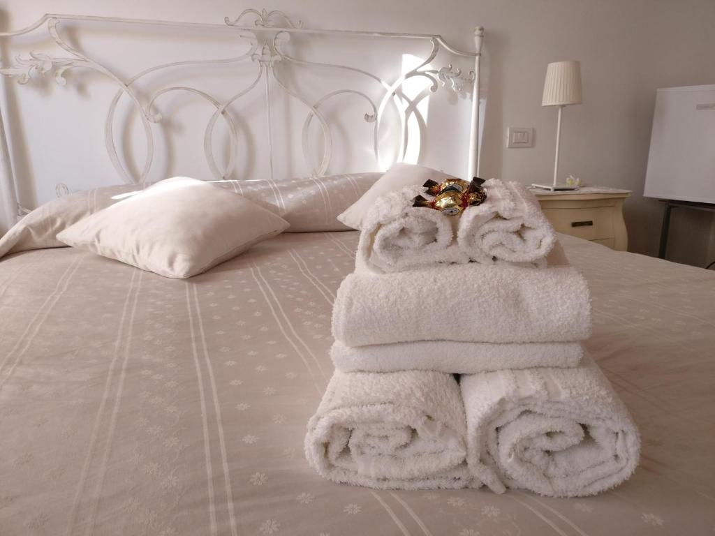 una pila de toallas sentadas encima de una cama en Al Piccolo Clarin, en Mestre