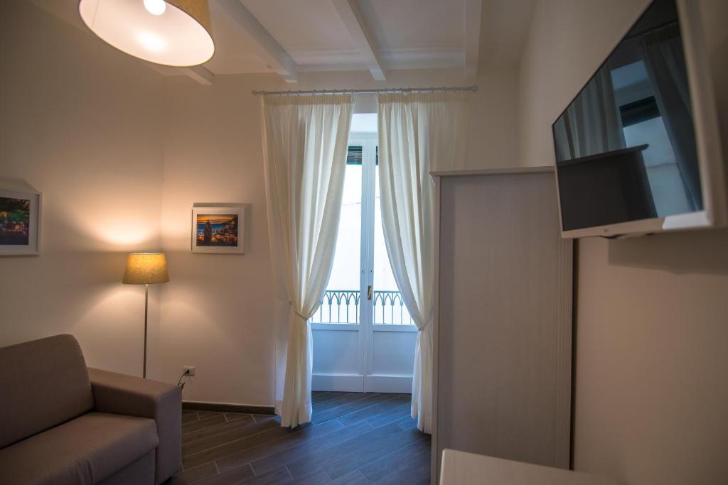 een woonkamer met een bank en een raam bij Maison del Mercante in Salerno