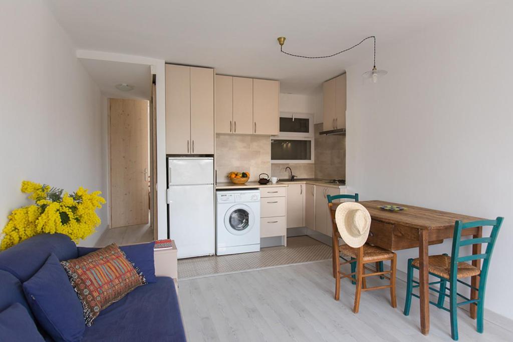 a living room with a table and a kitchen at Acogedor apartamento en el centro de Llançà in Llança