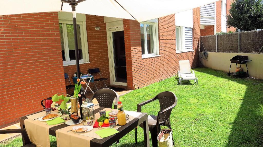a table with food and drinks on it in a backyard at Mia Beach-City apartment in Montgat