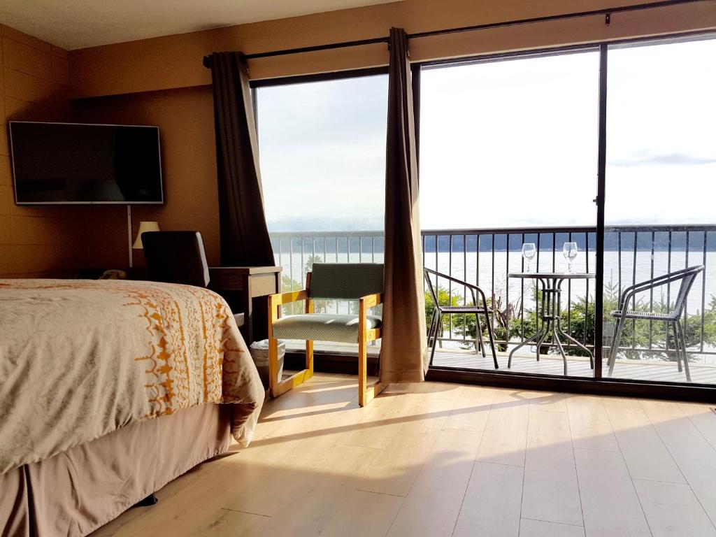 a bedroom with a bed and a view of the ocean at Above Tide Motel in Campbell River