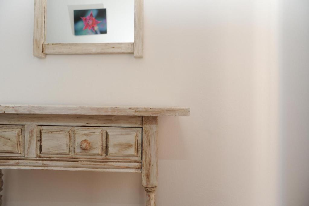 una mesa de madera con un espejo en la pared en Viviendas Turisticas S'Estanyol en La Savina