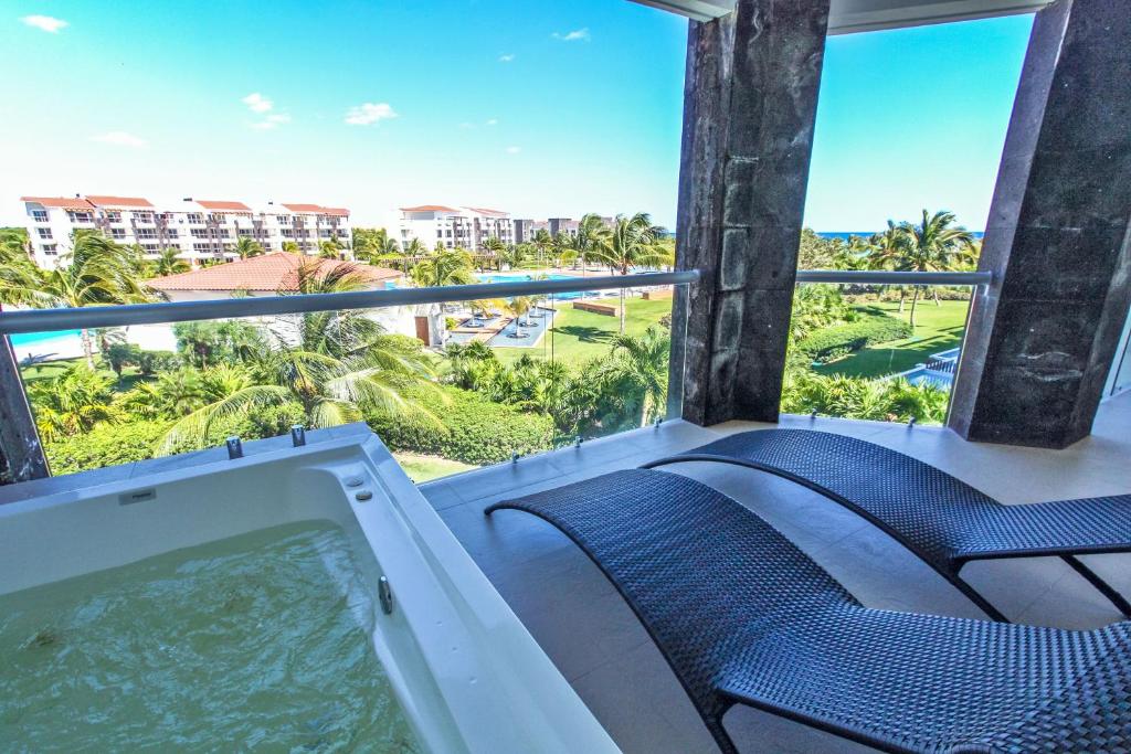 uma banheira de hidromassagem na varanda de um resort em Condo Buena Vida - Luxury Ocean View at Mareazul em Playa del Carmen
