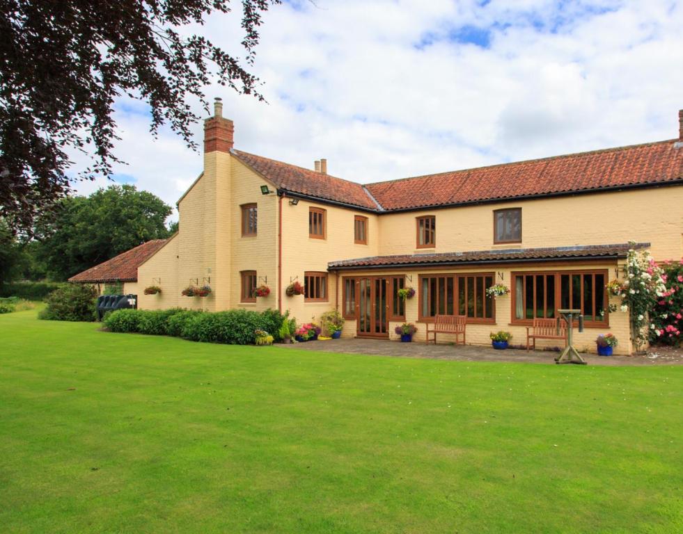 a large house with a large lawn in front of it at Wood Farm Kerdiston in Reepham