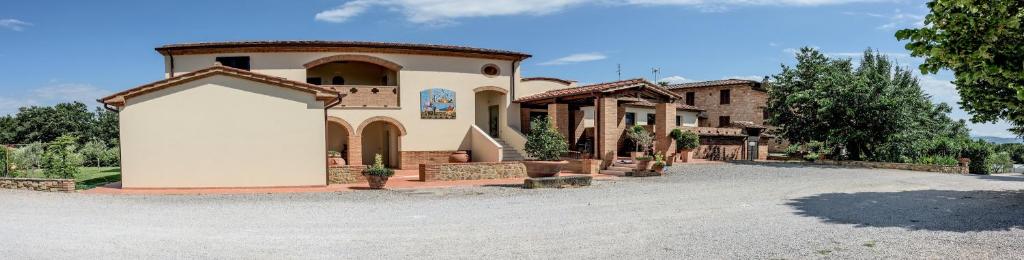 a large house with a garage in a driveway at Albergo La Foresteria in Bettolle
