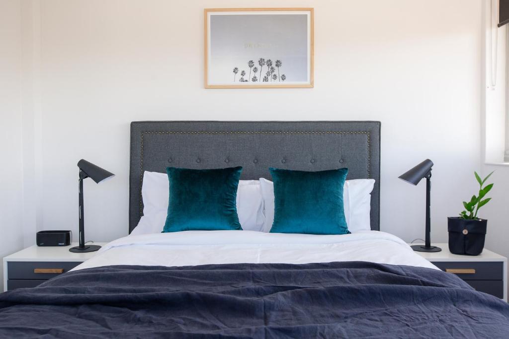 a bedroom with a large bed with blue pillows at Ridge Apartment Hotel in Brisbane