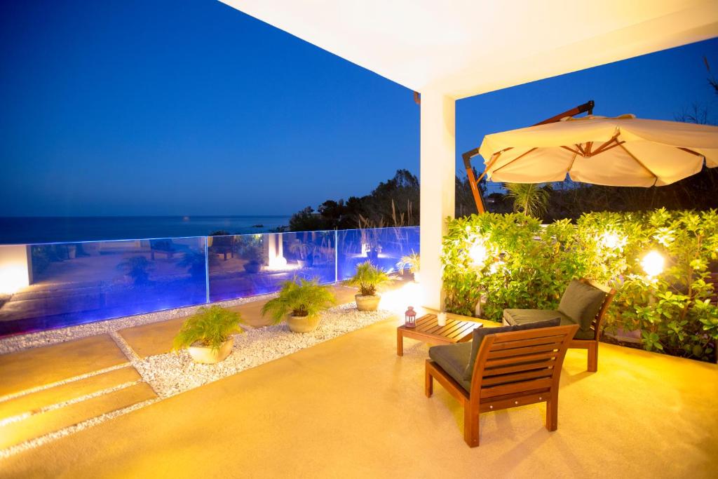 a patio with chairs and an umbrella at night at A Tonnara in Cefalù