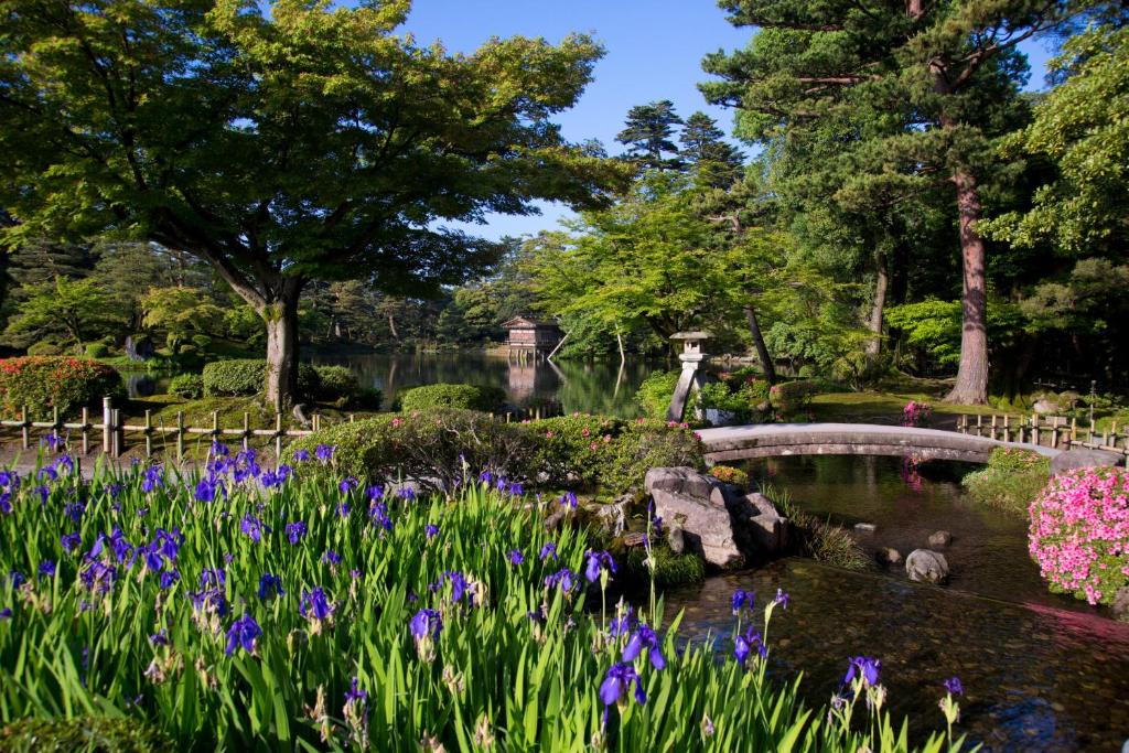 a garden with purple flowers and a pond at Hotel Nikko Kanazawa in Kanazawa