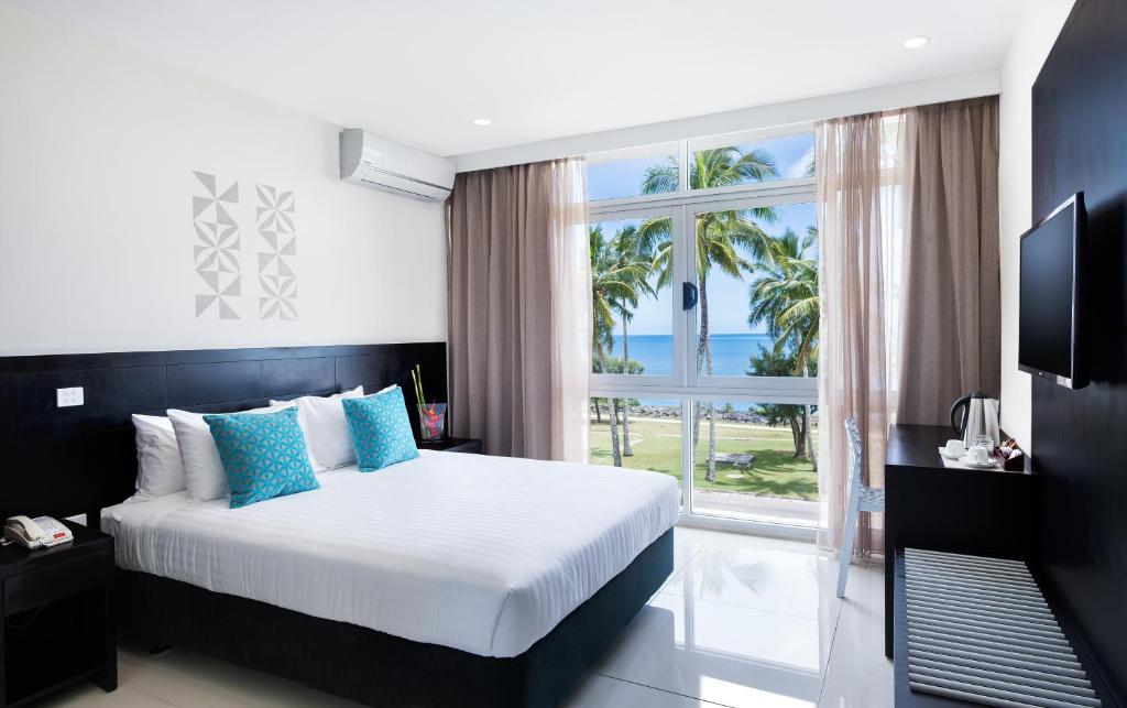 a bedroom with a bed and a large window at Tanoa International Dateline Hotel in Nuku‘alofa
