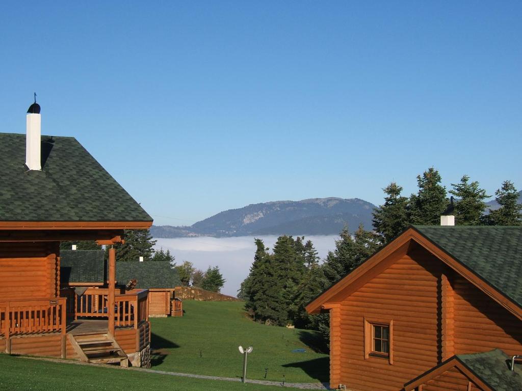 a log cabin with a porch and a deck at Kedros Village in Karpenisi