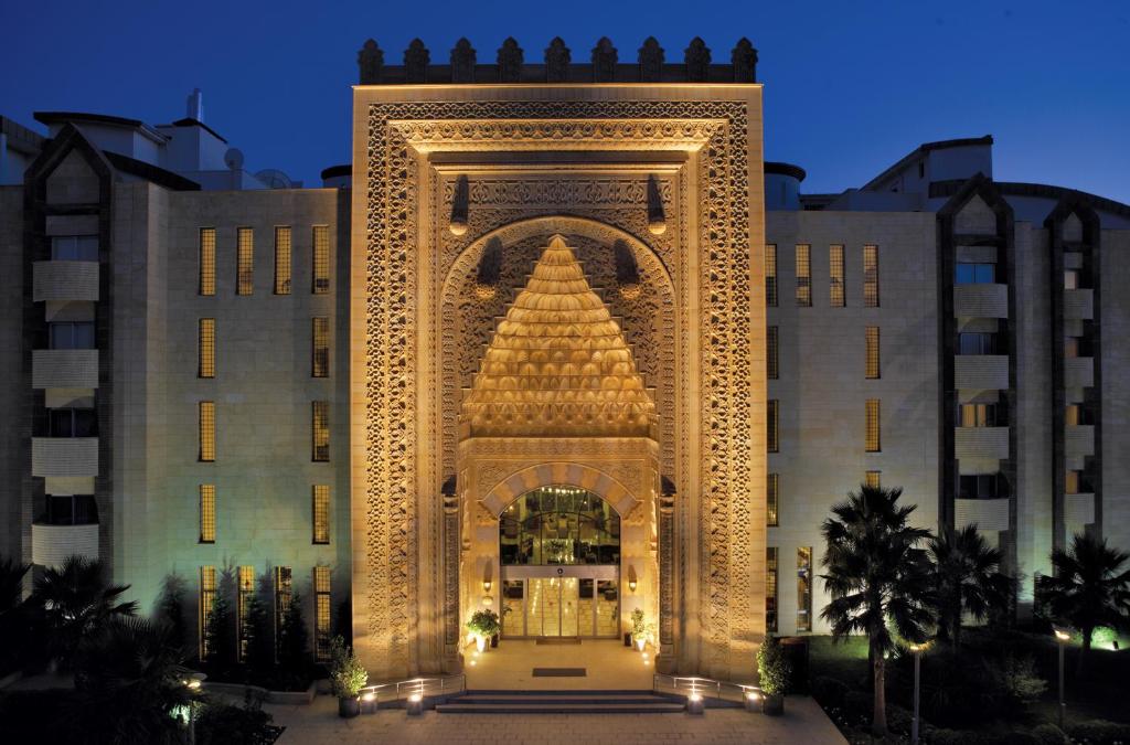 a large building with an arch in front of it at Mukarnas Spa & Resort Hotel in Okurcalar