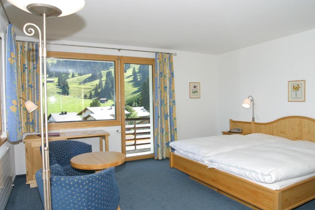 Postel nebo postele na pokoji v ubytování Hotel Alpina Parpan
