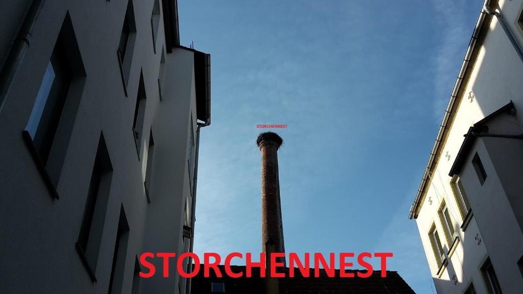 a tall tower is in the middle of a street at Storchennest in Fürth