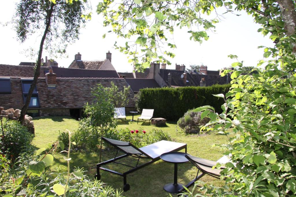um jardim com cadeiras e uma mesa no quintal em L'Hibernie em Rochefort-en-Yvelines