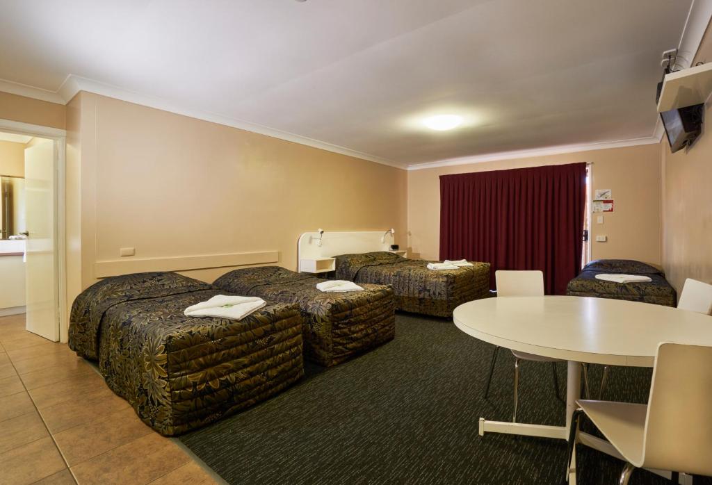 
a hotel room with two beds and a television at Jefferys Motel in Toowoomba
