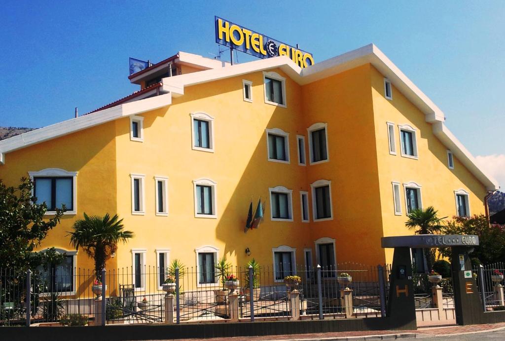 un grand bâtiment jaune avec un panneau d'hôtel dans l'établissement Hotel Euro, à San Giovanni Rotondo